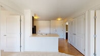 Located in Mill Creek, WA, this two-bedroom, one-bathroom residence offers a thoughtfully arranged single-floor layout that maximizes functionality. The open-concept living area seamlessly connects the living room, dining space, and kitchen, creating an inviting, cohesive environment. The kitchen is well-appointed with dark espresso cabinetry, light countertops, a full suite of black appliances including a refrigerator, range, microwave, and dishwasher, and warm hardwood-style flooring that extends throughout the main living areas.

The primary bedroom is a comfortable retreat, complete with a sliding glass door that opens to a private balcony with outdoor views. A second bedroom benefits from a large window that fills the room with natural light and overlooks the surrounding greenery. Both bedrooms feature plush carpet flooring. Three closets throughout the unit — including a spacious walk-in with built-in wire shelving — provide generous storage.

The bathroom is finished with dark wood cabinetry, a wide vanity with a single sink, and hardwood-style flooring, offering a clean and practical design. The overall aesthetic is bright and neutral, with white walls and flush-mount lighting creating a welcoming ambiance throughout.