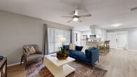 Located in Temple Terrace, Florida, this single-story, 2-bedroom, 2-bathroom residence offers a well-designed layout across a comfortable footprint. The open-concept living and dining area forms the heart of the home, featuring light wood-look flooring, neutral gray walls, and a ceiling fan overhead. A large window allows natural light to fill the space, complementing the easy flow into the kitchen. The kitchen is outfitted with white shaker-style cabinetry, a subway tile backsplash, stainless steel appliances including a refrigerator, range, and microwave, and light countertops. A breakfast bar with seating connects the kitchen to the living area. A discreet laundry closet with full-size washer and dryer is tucked conveniently within the kitchen area. Both bedrooms feature plush carpet flooring, ceiling fans, mirrored sliding closet doors, and a calm, neutral color palette. The spacious primary bedroom receives natural light through a large window. Each bathroom includes a tub-shower combination with tile surround and tile flooring. Throughout the residence, the design maintains a consistent, clean aesthetic suited to comfortable everyday living.