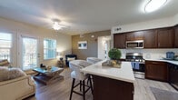 Located at 112 W River Rd in Ripon, California, this single-story unit offers a thoughtfully designed open-concept layout that seamlessly connects the kitchen, dining, and living areas. The kitchen is a standout feature, equipped with rich dark-walnut cabinetry, stainless steel appliances including a gas range, microwave, dishwasher, and refrigerator, and a light quartz-topped island with bar seating. Light wood-style flooring runs throughout the main living areas, complementing the neutral color palette. A ceiling fan adds comfort to the living room, which benefits from natural light streaming through windows fitted with horizontal blinds. An in-unit stacked washer and dryer is conveniently accessible from the kitchen area.

The two bedrooms are carpeted and well-lit, each featuring windows that allow natural light and views of the surrounding greenery. Closet space is provided in the bedrooms, with one featuring a dedicated closet with rod and shelf storage. The bathrooms include dark cabinetry vanities with light countertops and wood-style flooring. One bathroom features a shower-tub combination, while a separate water closet provides additional privacy. The overall ambiance is clean, modern, and move-in ready.