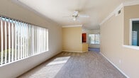 This single-story, 3-bedroom, 2-bathroom home offers a well-designed layout with comfortable living spaces throughout. The open living and dining area greets you at the entry, featuring plush carpet, crown molding, a ceiling fan with light fixture, and wide vertical-blind windows that flood the space with natural light. The adjoining dining nook is accented by a pendant light and flows seamlessly into the kitchen.

The kitchen is well-appointed with warm wood cabinetry, granite-style countertops, a full suite of black appliances including a gas range, built-in microwave, dishwasher, and refrigerator, plus a skylight and a window overlooking the outdoors. Wood-look flooring adds a clean, modern touch.

The primary bedroom offers generous proportions with carpeted flooring, and is complemented by a spacious walk-in closet featuring wire shelving for ample storage. The two additional bedrooms are carpeted and bright, each with panel-style closet doors. Both bathrooms are well-finished; one includes a soaking tub with full tile surround, wood-look flooring, and a vanity with granite-style countertops. A dedicated laundry room houses a full-size washer and dryer with overhead shelving, adding everyday convenience to this practical and inviting home.