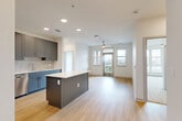 Located at 1450 Morrison Road in Denver's vibrant 80204 corridor, this well-appointed two-bedroom, two-bathroom residence offers a thoughtfully designed open-concept layout with contemporary finishes throughout. Light hardwood flooring flows through the main living areas, anchoring a bright, airy atmosphere enhanced by recessed lighting and a ceiling fan overhead.

The kitchen is a standout, featuring sleek gray shaker cabinetry, a classic subway tile backsplash, white quartz countertops, a central island, and a full suite of stainless steel appliances including a French door refrigerator, range, microwave, and dishwasher. The kitchen opens seamlessly to the dining and living areas, creating an ideal space for entertaining.

The living room is filled with natural light from large windows and offers direct access to a private balcony with sweeping views of the surrounding Denver cityscape. Both bedrooms feature plush carpeting, ceiling fans, and generous windows that bring in abundant daylight. The primary bedroom is comfortably sized with dedicated closet space.

The two bathrooms are finished with modern gray cabinetry and white quartz vanity tops. The primary bath includes a dual-sink vanity and wall-mounted mirror, while the second bath offers a soaking tub with marble-style tile surround. Three closets provide ample storage throughout the home.