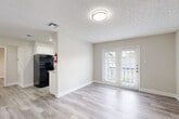 Located at 3030 Elmside Dr in Houston, TX, this single-story, one-bedroom, one-bathroom unit offers a well-designed layout across a comfortable floor plan. Light wood-style flooring flows consistently throughout the entire space, complementing the neutral, warm-toned walls and white trim found in every room.

The living room is bright and open, anchored by elegant French doors that flood the space with natural light and provide access to a private outdoor balcony. The adjacent dining area transitions naturally into the galley-style kitchen, which features white cabinetry, granite-style countertops, a subway tile backsplash, and black appliances including a refrigerator and electric range. A dedicated utility room adds practical functionality.

The bedroom is a comfortable, well-proportioned retreat equipped with a ceiling fan and a sliding closet door, with a window that brings in additional natural light. The unit also benefits from an abundance of closet storage, with five closets distributed throughout. A hallway connects the main living areas to the bedroom and bathroom.

The bathroom is finished in a clean, modern style, showcasing a granite-topped vanity with white cabinetry, subway tile surrounding the shower-tub combo, and consistent light wood-style flooring. Textured ceilings are featured throughout, adding a classic touch to the overall design.
