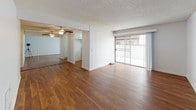Located at 20430 Leapwood Ave in Carson, CA, this single-floor unit offers a practical and comfortable layout with a blend of warm wood-style flooring and plush carpeting throughout. The open living area is bright and spacious, featuring rich hardwood-style floors, a textured ceiling, a ceiling fan, and a large sliding glass door that fills the space with natural light and provides access to an outdoor area. A wall-mounted heater unit adds functional convenience to the living space.

The kitchen is well-appointed with white cabinetry, a tile countertop, an electric range with overhead ventilation hood, and a window that brings in additional natural light. Adjacent areas feature mirrored closet doors, adding depth and brightness to the space.

The carpeted bedrooms offer a cozy retreat, each with vertical blinds over windows that allow for natural light while maintaining privacy. One bedroom also features a wall-mounted air conditioning unit for personalized comfort.

The bathroom is finished with wood-style flooring, a white vanity with a vessel sink, stone-toned countertops, and a full tub-shower combination. The clean, neutral color palette throughout the unit creates a cohesive and move-in-ready environment.