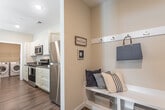 Located at 1000 Jensten Loop in Suffolk, Virginia, this single-floor home offers a well-designed layout with a cohesive coastal aesthetic throughout. The kitchen is a functional centerpiece, featuring crisp white shaker-style cabinetry reaching to the ceiling, granite countertops, stainless steel appliances including a range, microwave, and refrigerator, and warm hardwood-style flooring. A breakfast bar provides additional seating and opens the space for easy entertaining.

The home includes multiple bedrooms, each carpeted for comfort and fitted with ceiling fans and ample natural light from windows dressed with navy curtain panels and blinds. The primary bedroom offers a generous layout with a closet, while additional bedrooms provide versatile living options.

Two bathrooms serve the home, each thoughtfully finished with granite-topped vanities, shaker-style cabinetry, and hardwood-style flooring. One bathroom features a full tub-shower combination, while the other includes a granite vanity with a large mirror.

A dedicated in-unit laundry room accommodates a full-size front-loading washer and dryer set, with overhead wire shelving for added storage. The living area carries the home's coastal theme, with neutral tones and warm carpeting creating an inviting, relaxed atmosphere throughout.