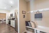 Located at 1000 Jensten Loop in Suffolk, Virginia, this single-floor home offers a well-designed layout with a cohesive coastal aesthetic throughout. The kitchen is a functional centerpiece, featuring crisp white shaker-style cabinetry reaching to the ceiling, granite countertops, stainless steel appliances including a range, microwave, and refrigerator, and warm hardwood-style flooring. A breakfast bar provides additional seating and opens the space for easy entertaining.

The home includes multiple bedrooms, each carpeted for comfort and fitted with ceiling fans and ample natural light from windows dressed with navy curtain panels and blinds. The primary bedroom offers a generous layout with a closet, while additional bedrooms provide versatile living options.

Two bathrooms serve the home, each thoughtfully finished with granite-topped vanities, shaker-style cabinetry, and hardwood-style flooring. One bathroom features a full tub-shower combination, while the other includes a granite vanity with a large mirror.

A dedicated in-unit laundry room accommodates a full-size front-loading washer and dryer set, with overhead wire shelving for added storage. The living area carries the home's coastal theme, with neutral tones and warm carpeting creating an inviting, relaxed atmosphere throughout.