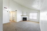 Located at 1904 N Midland Dr in Midland, Texas, this single-story home offers a well-organized layout with comfortable living spaces throughout. The living room is a standout feature, boasting soaring vaulted ceilings with a textured finish, soft carpeted flooring, and a classic wood-burning fireplace framed by a tiled hearth and mantel shelf. Natural light filters in through a large window, enhancing the open and airy atmosphere. A clear sightline connects the living area to the hallway, which leads to the private quarters of the home.

The galley-style kitchen is efficiently designed with ample white cabinetry, light countertops, a double sink, and black appliances including an electric range and dishwasher. Tile flooring and a window above the sink keep the space bright and functional.

The bedrooms are generously sized, each featuring plush carpeting, ceiling fans with lighting, and natural light from windows with blinds. One bedroom offers dual closets with rod-and-shelf organizers, providing excellent storage. An additional carpeted room with sliding glass door access to the exterior offers flexible use as a bedroom, office, or sitting area.

The bathroom includes a full tiled tub-and-shower combination with classic chrome fixtures. Throughout the home, a consistent neutral palette and textured ceilings contribute to a clean, understated aesthetic.