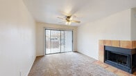 Located in Tucson, AZ, this single-floor, 2-bedroom, 3-bathroom residence offers a functional and comfortable layout. The living room serves as the heart of the home, featuring plush carpeting, a ceiling fan with light fixture, and a striking tile-surround fireplace as a focal point. A full-width sliding glass door with vertical blinds floods the space with natural light and provides direct access to the outdoor patio. The galley-style kitchen is well-appointed with white cabinetry, ample counter space, white appliances including a range, microwave, refrigerator, and dishwasher, all complemented by wood-look flooring. Both bedrooms are carpeted and bright, with the second bedroom featuring a window with vertical blinds that brings in natural light. Each bedroom is supported by dedicated closet space. The three bathrooms include units with tub/shower combinations and wood-look flooring, while at least one bathroom features an extended vanity with white cabinetry, a large mirror, and globe lighting. Additional conveniences include an in-unit laundry area. Neutral tones and clean finishes throughout create a cohesive, move-in-ready atmosphere.