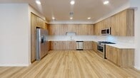 Located at 398 West Valley Boulevard in San Gabriel, CA, this well-designed 2-bedroom, 3-bathroom residence offers a thoughtfully laid-out single-floor plan with a clean, contemporary aesthetic throughout. The open-concept kitchen and living area serves as the heart of the home, showcasing warm wood-toned cabinetry that extends floor to ceiling, sleek light wood vinyl flooring, and a full suite of stainless steel appliances including a refrigerator, gas range, microwave, and dishwasher. Recessed lighting illuminates the space evenly, enhancing the bright and airy atmosphere. The generously sized primary bedroom provides a comfortable retreat, while the second bedroom features plush carpeting and glass French doors that open to an outdoor balcony with neighborhood views. Additional bedrooms and common areas are finished with soft carpet or light wood flooring, maintaining a cohesive, neutral palette throughout. The three bathrooms are well-appointed, with one featuring a sliding glass shower-tub enclosure, warm wood vanity cabinetry, and large-format tile flooring. A hallway connects the various spaces efficiently. Neutral wall tones, recessed lighting, and consistent modern finishes give the entire residence a clean, move-in-ready feel.