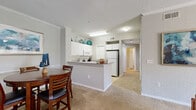Located at 3240 SW 34th St in Ocala, Florida, this single-floor residence offers a thoughtfully designed layout that balances comfort and functionality. The open-concept living and dining area is anchored by plush carpeting and crowned with elegant crown molding, creating a warm and inviting atmosphere. Large sliding glass doors allow abundant natural light to fill the living room, which features a ceiling fan and ample space for relaxed entertaining.

The kitchen is equipped with white cabinetry, tile backsplash, a full suite of appliances including a refrigerator, electric range, and built-in microwave, and a peninsula counter that connects seamlessly to the dining area — ideal for casual meals or meal prep.

The bedroom is generously proportioned with tray ceilings, a ceiling fan, soft carpeting, and access to a spacious walk-in closet outfitted with wire shelving for organized storage. The primary bathroom features dual sinks set into a wide white vanity, a large mirror, and a separate water closet. A second full bathroom includes a single-sink vanity, tub-shower combination, and tile flooring.

Neutral tones throughout the space create a clean, cohesive aesthetic, while the efficient single-floor plan ensures easy accessibility and a comfortable everyday living experience.
