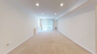 Located at 60 Waterfall Dr in Canton, MA, this single-floor residence offers a thoughtfully laid-out living space designed for both comfort and functionality. The expansive main living area is carpeted in warm neutral tones and illuminated by recessed lighting throughout, creating a bright and welcoming atmosphere. A large sliding glass door with vertical blinds floods the space with natural light while providing access to the outdoors. The kitchen is well-appointed with light wood cabinetry, dark granite-style countertops, and a full suite of stainless steel appliances, including a range, over-the-range microwave, and dishwasher, all set on light tile flooring. The bedrooms are generously sized, each featuring soft wall-to-wall carpeting, recessed lighting, and ample closet space with built-in hanging rods. Windows dressed with blinds allow for natural light while maintaining privacy. The bathrooms are clean and functional, finished in crisp white with tile flooring, vanities with mirrored medicine cabinets, and bright vanity lighting. The overall design aesthetic throughout is neutral and move-in ready, offering a versatile canvas suited to a variety of living arrangements.