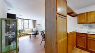 Located at 1509 Tenth Ave S in Minneapolis, MN, this one-bedroom, one-bathroom unit offers a functional and efficiently designed single-floor layout. Warm hardwood flooring flows throughout, tying the spaces together cohesively.

The combined kitchen and living area forms the heart of the unit. The kitchen features warm oak cabinetry with ample storage, white countertops, a double-basin sink, and a full-size refrigerator — providing all essential functionality in a compact footprint. A partial dividing wall with additional cabinetry separates the kitchen from the living area, which is bright and inviting thanks to large corner windows that draw in generous natural light and offer open city views.

The spacious bedroom is a comfortable retreat, featuring a large window with city views, light hardwood flooring, and a built-in sliding-door closet providing practical storage. The bathroom is neatly appointed with a shower/tub combination, a wood-framed vanity with a white countertop, mosaic tile flooring, and a wall-mounted shelving unit for added storage.

Throughout the unit, neutral wall tones, textured ceilings, and consistent hardwood flooring create a clean, cohesive aesthetic suited for everyday living in the heart of Minneapolis.