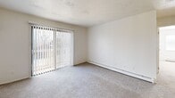Located at 4030 Hartford Rd in Lansing, Michigan, this single-floor unit offers a clean, functional layout designed for comfortable everyday living. The living area is generously sized, featuring soft carpet flooring, baseboard heating, and a full wall of vertical-blind sliding glass doors that invite abundant natural light and provide views of the surrounding outdoors.

The galley-style kitchen is efficiently laid out with white shaker cabinetry, light stone-patterned countertops, a double-basin stainless steel sink, and wood-look vinyl plank flooring. It is equipped with a gas range and a stainless steel refrigerator, offering a practical and well-appointed cooking space.

The bedrooms are carpeted and bright, each featuring baseboard heating and windows with blinds for light control. Closet space is well-provided, with units featuring louvered bi-fold doors, hanging rods, and built-in shelving for organized storage. One bedroom includes a dedicated closet adjacent to the kitchen area, adding versatility to the floor plan.

The bathroom is clean and straightforward, featuring a full-size soaking tub and shower combination with chrome fixtures. Throughout the unit, white walls and neutral tones create a bright, cohesive atmosphere that is easy to personalize.