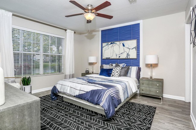 Master bedrooms featuring wood-style flooring, a walk-in closet, and a ceiling fan. - Emerson Isles II