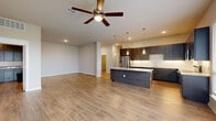 Located in Houston's 77084 zip code, this single-story, 4-bedroom, 5-bathroom home offers a thoughtfully designed open-concept layout with modern finishes throughout. The combined kitchen and living area serves as the heart of the home, featuring warm hardwood-style flooring, recessed lighting, and a ceiling fan that enhances the airy, welcoming atmosphere. The chef's kitchen is outfitted with dark espresso cabinetry, granite countertops, stainless steel appliances, a subway tile backsplash, and a large center island with a built-in wine rack and pendant lighting — ideal for both everyday living and entertaining. Expansive windows and glass doors flood the space with natural light and provide views to the outdoors. The generously sized primary bedroom includes dedicated closet space and an en-suite bathroom featuring elegant floor-to-ceiling tile, a soaking tub, and a separate shower. Three additional well-proportioned bedrooms offer flexibility for guests, offices, or family use, each with hardwood-style floors and access to one of the five bathrooms. A dedicated laundry room is equipped with full-size washer and dryer units, granite countertops, and ample cabinetry for storage, rounding out this well-appointed home.