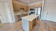 This contemporary 920 square foot apartment in Bogota, NJ, offers a well-designed living space with two bedrooms and one bathroom. The heart of the home is an open-concept kitchen and living area, showcasing a modern aesthetic with light wood cabinetry, quartz countertops, and stainless steel appliances. The kitchen's L-shaped design maximizes functionality, while recessed lighting enhances the bright, airy atmosphere.

Throughout the apartment, warm-toned hardwood floors create a cohesive look and add a touch of elegance. Large windows in the bedrooms and living area allow for ample natural light, contributing to the spacious feel. The primary bedroom, measuring 270 square feet, provides a generous retreat.

The bathroom features a modern vanity with wooden cabinetry, complemented by neutral-toned tile flooring and a tub/shower combination with sleek fixtures. Two closets offer additional storage space, enhancing the apartment's practicality.

A standout feature is the balcony accessible from the living area, providing outdoor space and views of the surrounding area. The apartment's clean lines, neutral color palette, and contemporary finishes create a stylish and comfortable urban living environment.