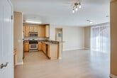 Located at 28000 S Western Ave in the San Pedro neighborhood of Los Angeles, this single-floor residence offers a well-organized layout with a clean, functional design. The open-concept kitchen and living area form the heart of the space, where light wood laminate flooring flows continuously throughout. The kitchen is well-appointed with warm honey-toned wood cabinetry, granite countertops, a breakfast bar peninsula, and a full suite of stainless steel appliances including a gas range, over-the-range microwave, refrigerator, and dishwasher — providing ample storage and counter space for everyday use. The adjoining living area is generously proportioned, bathed in natural light through large sliding glass doors dressed with vertical blinds that offer outdoor access and views. Bedrooms are bright and airy, each featuring multiple windows with vertical blinds that allow for adjustable natural light, complemented by the same consistent wood-style flooring. The bathrooms are finished with granite-topped vanities, warm wood cabinetry, tile flooring, and tub-shower combinations enclosed by sliding glass doors. The overall aesthetic is neutral and well-maintained, offering a move-in-ready environment with a cohesive, practical design throughout.