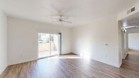 Located at 1711 W Henderson Ave in Porterville, California, this well-appointed 2-bedroom, 2-bathroom single-floor residence offers a thoughtfully designed layout across a comfortable footprint. The bright living room features wood-look hardwood-style flooring, a ceiling fan, and large sliding glass doors that open to a private patio, flooding the space with natural light and providing outdoor access. The open kitchen and dining area is outfitted with white cabinetry, granite-style countertops, and white appliances, with a breakfast bar separating the kitchen from the adjacent dining space. A pendant light fixture accents the dining area, which also benefits from natural light through vertical blinds. Both bedrooms are carpeted and include ceiling fans and closets, with the spacious primary bedroom offering generous room to furnish. The two bathrooms feature wood-look flooring, white vanities with granite countertops, and a bathtub with shower. Additional spaces include a hallway, laundry area, pantry, utility room, and multiple closets throughout, offering ample storage. The clean, neutral color palette and consistent finishes lend a cohesive, move-in-ready ambiance throughout the entire residence.