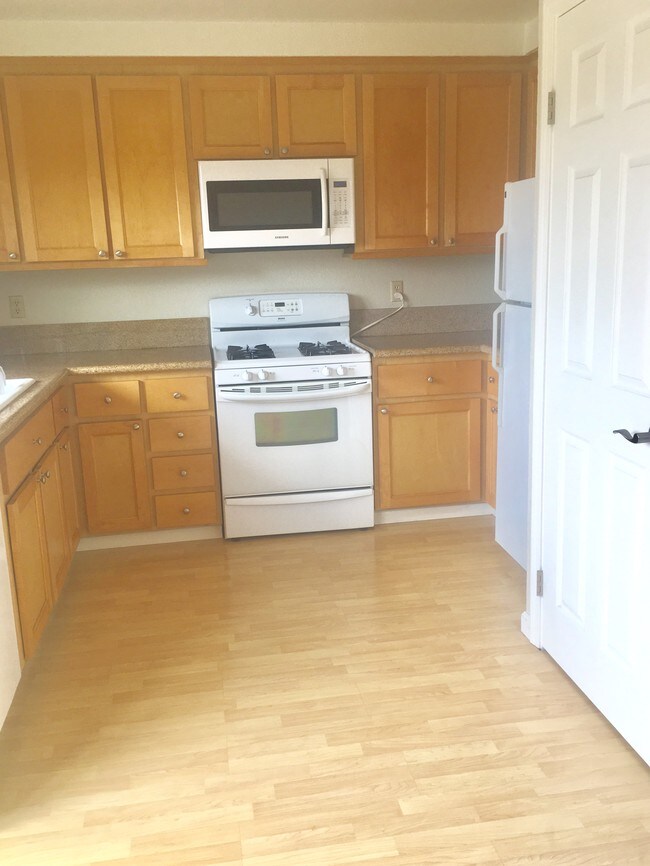 Cocina con estufa de gas y pisos símil madera y encimera de mármol. - 419 Sailfish Dr