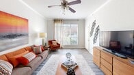 This single-floor, one-bedroom, one-bathroom residence offers a thoughtfully designed layout that maximizes its compact footprint across five distinct spaces. The living room is bright and welcoming, featuring wood-look vinyl flooring, crown molding, and a ceiling fan. A large window fills the room with natural light, while the open arrangement comfortably accommodates a seating area and media space.

The kitchen is efficiently designed with white cabinetry reaching toward the ceiling, dark granite countertops, tile flooring, and stainless steel appliances including a dishwasher and electric range. A pantry door adds practical storage within the kitchen's galley-style configuration.

The bedroom is a comfortable retreat with plush carpeting, two windows fitted with blinds that allow ample natural light, a ceiling fan, and a closet. The room offers a relaxed and private atmosphere suited for rest.

The bathroom is clean and functional, featuring tile flooring, a vanity with a large framed mirror, and a shower-tub combination with a curtain. Neutral tones throughout create a calm, cohesive aesthetic.

A hallway connects the main spaces, contributing to an efficient and practical floor plan. Overall, this residence presents a clean, modern interior with consistent neutral tones accented by warm décor throughout.