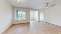Located at 320 Fisher St in Charlottesville, VA, this single-floor residence offers a thoughtfully designed open layout with modern finishes throughout. The living area features warm light wood flooring, neutral walls, and a multi-bulb track light fixture, creating a clean and welcoming atmosphere. A dedicated dining nook provides direct access to an outdoor balcony through a glass-panel door, with a large window framing views of lush greenery.

The kitchen is a standout feature, anchored by a central island with a granite countertop and integrated sink, illuminated by pendant lighting. Light wood cabinetry lines the walls, complemented by a classic subway tile backsplash and a full suite of stainless steel appliances, including a range, microwave, and refrigerator.

Bedrooms are carpeted for comfort, with one featuring a ceiling fan and generous natural light from a large window. The bathrooms are finished with granite-topped vanities, light wood cabinetry, and hardwood-style flooring; the primary bath includes a glass-enclosed walk-in shower. A dedicated laundry room with full-size washer and dryer adds practical convenience. The space presents a clean, contemporary design throughout.