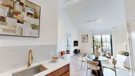 Located at 100 East Putnam Avenue in Greenwich, CT, this thoughtfully designed one-bedroom, one-bathroom residence offers a refined living experience across a well-proportioned single floor. The open-concept kitchen and living area immediately impresses with dramatic vaulted ceilings and light-toned herringbone hardwood flooring that flows throughout the space. The kitchen is outfitted with rich walnut cabinetry, sleek white quartz countertops with a matching backsplash, stainless steel appliances, and a distinctive gold-toned faucet, blending warmth with modern sophistication. The living room provides generous space for both relaxing and dining, with natural light streaming in through large black-framed windows and access to a private balcony. A dedicated second living area offers additional flexibility. The bedroom is a calm retreat featuring vaulted ceilings, a natural light-filled window, and direct access to multiple closets. The bathroom is finished with neutral square wall tiles, large-format floor tiles, a walnut floating vanity, a soaking tub with shower, and coordinating brass fixtures. Additional conveniences include an in-unit laundry, utility room, and hallway with ample storage throughout.