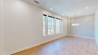 Located in the heart of Charleston, SC, this well-appointed 2-bedroom, 2-bathroom residence offers a thoughtfully designed single-floor layout. The open-concept living, dining, and kitchen area serves as the heart of the home, featuring warm hardwood-style flooring, recessed lighting, and a bank of large double-hung windows that flood the space with natural light and offer views of the surrounding cityscape. A sleek pendant light fixture anchors the dining area. The kitchen is a standout, showcasing a bold cobalt-blue island with a white quartz countertop, an undermount sink, and three glass pendant lights overhead. Gray shaker-style cabinetry lines the walls, complemented by a white subway tile backsplash and professional-grade stainless appliances. A dedicated pantry and laundry room add everyday convenience. The generously sized primary bedroom includes a well-organized walk-in closet with built-in shelving and hanging systems. The bathrooms feature elegant finishes, including light blue vanity cabinetry, quartz countertops, gold-toned fixtures, large-format tile flooring, and framed mirrors. Additional spaces include a dedicated office, multiple closets, and clean, minimalist hallways throughout.