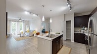 Located at 823 S Church St in Greenville, SC, this single-floor residence offers a thoughtfully designed layout with modern finishes and a bright, open atmosphere. The open-concept kitchen is a standout feature, equipped with dark espresso cabinetry, stainless steel appliances, granite countertops, and a central island with pendant lighting and bar seating — ideal for both cooking and casual dining. Track lighting and wood-style flooring carry throughout the main living areas, adding a cohesive, contemporary feel. The living room is generously proportioned, bathed in natural light from large sliding glass doors that open to a private balcony with outdoor views. Ceiling fans are present in both the living room and additional rooms, enhancing comfort throughout. The bedroom features plush carpeting and ample space, while a dedicated flex room with a ceiling fan and natural window light offers versatility as a home office or guest room. A walk-in closet provides substantial storage with built-in shelving. The bathroom is finished with granite countertops, dark wood cabinetry with brushed nickel hardware, a wide vanity mirror, and stylish overhead lighting. Overall, this residence combines functional design with modern aesthetics in a well-appointed Greenville location.