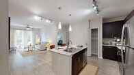 Located at 823 S Church St in Greenville, SC, this single-floor residence offers a thoughtfully designed layout with modern finishes and a bright, open atmosphere. The open-concept kitchen is a standout feature, equipped with dark espresso cabinetry, stainless steel appliances, granite countertops, and a central island with pendant lighting and bar seating — ideal for both cooking and casual dining. Track lighting and wood-style flooring carry throughout the main living areas, adding a cohesive, contemporary feel. The living room is generously proportioned, bathed in natural light from large sliding glass doors that open to a private balcony with outdoor views. Ceiling fans are present in both the living room and additional rooms, enhancing comfort throughout. The bedroom features plush carpeting and ample space, while a dedicated flex room with a ceiling fan and natural window light offers versatility as a home office or guest room. A walk-in closet provides substantial storage with built-in shelving. The bathroom is finished with granite countertops, dark wood cabinetry with brushed nickel hardware, a wide vanity mirror, and stylish overhead lighting. Overall, this residence combines functional design with modern aesthetics in a well-appointed Greenville location.