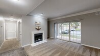 Located at 1121 Prairie Pt in O'Fallon, MO, this 2-bedroom, 1-bathroom residence offers a practical and comfortable single-floor layout. The living room serves as the heart of the home, highlighted by a white-framed fireplace, crown molding, plush carpeting, and a sliding glass door that fills the space with natural light and provides views of the surrounding greenery. Adjacent to the living area, a dining space with wood-look flooring and a pendant light fixture connects seamlessly to the galley-style kitchen, which features warm wood cabinetry, granite-style countertops, stainless steel and black appliances, and durable wood-look tile flooring. A central hallway leads to both bedrooms, each finished with soft carpeting. The primary bedroom is generously sized and the second bedroom includes a ceiling fan and a window overlooking the exterior. The full bathroom offers a wood-vanity with a granite-style countertop, overhead cabinetry, a tub-shower combination, and wood-look tile flooring. A dedicated laundry room with built-in shelving and an in-unit washer adds everyday convenience. Neutral gray walls and consistent finishes throughout lend the space a cohesive, move-in-ready feel.