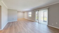 Located in Saint Petersburg, FL, this single-floor, three-bedroom, two-bathroom residence offers a well-designed layout across a comfortable footprint. Light wood-style flooring flows consistently throughout the living areas and bedrooms, complemented by neutral gray walls and crisp white trim that create a clean, cohesive aesthetic. The spacious living room features a textured ceiling, crown molding, a large sliding glass door, and an additional window that invite abundant natural light and provide views of the outdoors. The galley-style kitchen is outfitted with white shaker cabinetry, brushed gold hardware, quartz countertops, a subway tile backsplash, a stainless steel sink, and a full suite of stainless steel appliances. The primary bedroom offers a generous layout with a dedicated closet, while two additional bedrooms provide flexible use with ample natural light. Both bathrooms are appointed with soaking tubs, full tub-surround marble-look porcelain tile, and brushed gold fixtures, delivering an elevated, refined look. A hallway connects the rooms efficiently, and two closets offer practical storage throughout. Textured ceilings are present in several rooms, adding a classic residential character to this well-appointed home.