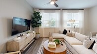 This contemporary 1,040 square foot home in Lakeland, Florida, offers a harmonious blend of style and functionality. The single-story layout features two bedrooms and two bathrooms, with the primary bedroom boasting a generous 150 square feet. The heart of the home is an open-concept kitchen and living area, characterized by sleek white cabinetry, stainless steel appliances, and a practical island with seating. Wood-look flooring throughout creates a cohesive, warm ambiance.

Large windows with plantation shutters flood the space with natural light, complemented by sheer curtains for a soft, airy feel. The living room is adorned with comfortable, neutral-toned furniture and accented with lush indoor plants, adding a touch of nature to the interior. Both bedrooms feature ceiling fans and continue the home's light, modern aesthetic with soothing color palettes and contemporary artwork.

The bathrooms showcase clean lines with white vanities, granite countertops, and spacious tub-shower combinations. A walk-in closet provides ample storage space. Throughout the home, thoughtful details such as recessed lighting, stylish fixtures, and carefully curated decor pieces elevate the overall design, creating a welcoming and sophisticated living environment.