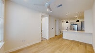 Located at 1606 North Saint Mary's Street in San Antonio, TX, this thoughtfully designed one-bedroom, one-bathroom residence offers a clean, modern aesthetic across a single floor. The open-concept layout seamlessly connects the kitchen, dining, and living areas, creating a bright and functional living space.

The kitchen is a standout feature, showcasing a two-tone design with warm wood lower cabinets and crisp white upper cabinets accented by matte black hardware. A peninsula with bar seating and pendant lighting serves as both a prep area and casual dining spot. Stainless steel appliances — including a range, over-the-range microwave, dishwasher, and French door refrigerator — complete the setup. Light hardwood flooring flows throughout the main living areas, enhancing the airy feel.

The living area offers comfortable proportions with recessed lighting and a ceiling fan. The bedroom is a serene retreat with a large window allowing natural light and direct access to the full bathroom. The bathroom features a white vanity with black fixtures, a glass-enclosed walk-in shower, and coordinating wood-look flooring. A well-organized walk-in closet with built-in shelving and multiple hanging rods provides generous storage.