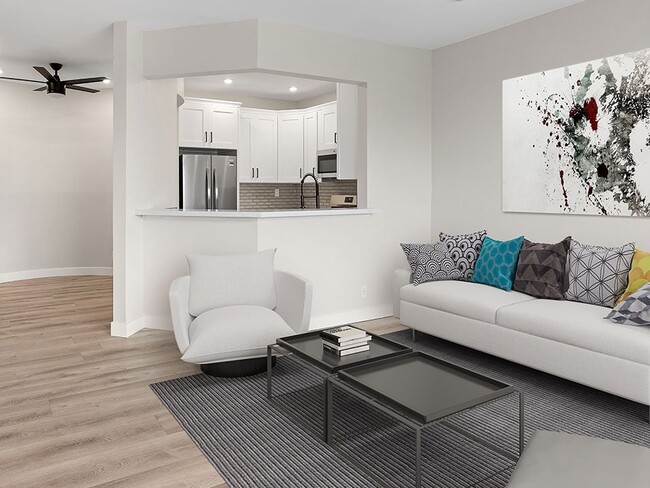 Hardwood floored living room with view of kitchen and dining area. - Clarington Court