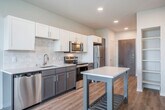 Located at 2876 Index Rd in Fitchburg, WI, this thoughtfully designed one-bedroom, one-bathroom unit offers a comfortable and modern living experience across a single floor. The entrance opens into a well-appointed kitchen that flows seamlessly toward the living area, creating an open and connected feel. The kitchen is outfitted with two-tone cabinetry — white uppers and gray lowers — complemented by a subway tile backsplash, light quartz countertops, a stainless steel sink, and a full suite of stainless steel appliances including a refrigerator, electric range, over-the-range microwave, and dishwasher. Recessed lighting and light wood-style flooring carry throughout the main living area, which benefits from natural light and sliding door access to a private balcony overlooking greenery. The bedroom is a bright, well-proportioned retreat featuring dual windows with outdoor views, a ceiling fan, and a dedicated closet. A hallway connects the bedroom to the clean, minimalist bathroom, which includes a wide vanity with an undermount sink, a full mirror, and a tub-shower combo. Additional storage is provided by an open shelving closet near the entrance. A wall-mounted thermostat and a split HVAC unit ensure year-round comfort throughout the space.