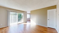 Located at 154 N Palmetto Ave in Ontario, CA, this 2-bedroom, 2-bathroom single-floor home offers a practical and comfortable layout. The open living and dining area features warm wood-style flooring, neutral-toned walls, and a textured ceiling. A sliding glass door floods the space with natural light and opens to a private balcony with pleasant outdoor views of mature greenery.

The kitchen is efficiently designed with white cabinetry, dark granite countertops, a breakfast bar peninsula, and wood-style flooring that carries throughout the main living areas. Ample cabinet storage and a full-size refrigerator complete the space.

Both bedrooms are carpeted and include ceiling fans with light fixtures and vertical blind-covered windows. The primary bedroom features a mirrored sliding closet door, while the second bedroom offers generous proportions. The home includes four closets total, providing excellent storage throughout.

The two bathrooms are finished with dark granite countertops, white vanity cabinetry, and wood-style flooring. One bathroom includes a soaking tub, while the other features a framed sliding glass shower enclosure. A utility room and hallway round out the thoughtfully arranged floor plan.