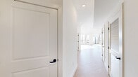 This well-appointed two-bedroom, three-bathroom residence in West Orange, NJ offers a thoughtfully designed single-floor layout with generous living space. The open-concept kitchen and living room serve as the heart of the home, where large floor-to-ceiling windows flood the area with natural light and provide sweeping views of the surrounding West Orange landscape. The kitchen is a standout, featuring bold two-tone cabinetry in blue and white, a large central island with quartz countertops, and a full suite of stainless steel appliances. Light hardwood flooring flows consistently throughout the unit, complementing the clean white walls and modern aesthetic. The spacious primary bedroom offers ample room and connects to a well-appointed en-suite bathroom with a double vanity, quartz countertops, gold hardware accents, and large-format marble-style tile flooring. Additional bathrooms echo the same refined design, featuring sleek gray cabinetry, matte black fixtures, and gold accents. A dedicated laundry bathroom adds convenience. The unit also includes four closets—one a generous walk-in—a utility room, hallway, and a private balcony accessible from the sun-drenched living area, perfect for enjoying outdoor views of the neighboring hillside.
