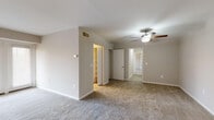 This single-floor residence offers a practical and comfortable layout designed for everyday living. The kitchen is efficiently arranged in a galley style, featuring warm honey-toned wood cabinetry, granite-look countertops, tile flooring, a white gas range with overhead ventilation, a dishwasher, and a full-size refrigerator. A window above the dining area fills the space with natural light and provides a pleasant outdoor view of surrounding greenery.

The living area is generously proportioned, featuring neutral-toned carpet and a clean, open feel that transitions smoothly into the rest of the home. A ceiling fan adds both function and a subtle design element to the space.

The primary bedroom is spacious and carpeted, highlighted by a ceiling fan and access to a well-sized walk-in closet with built-in shelving. Additional bedrooms are similarly carpeted and include their own closet storage, making each room practical and move-in ready.

The bathroom is finished with tile flooring and tile surround in the shower/tub area, complemented by a white vanity with a sink and a medicine cabinet mirror. Clean, neutral tones throughout the home create a cohesive and inviting ambiance, while the thoughtful floor plan ensures a smooth flow between all areas of the residence.