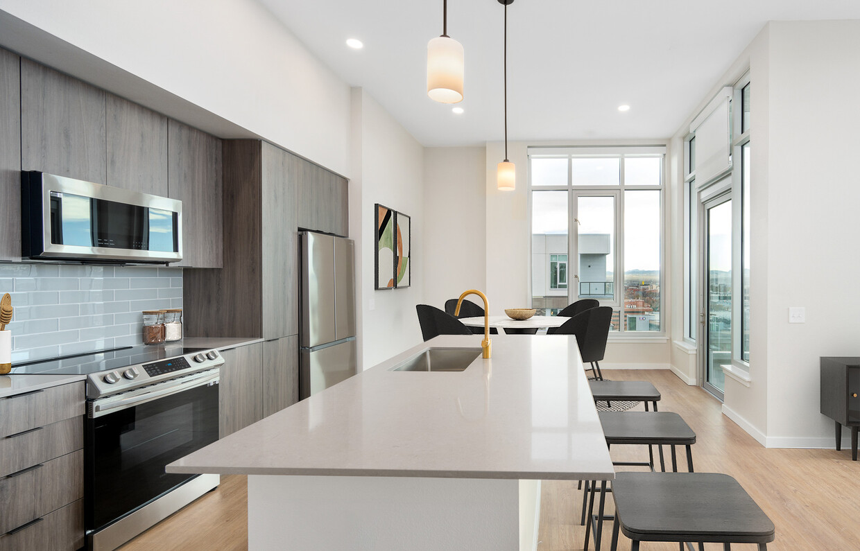 Signature Collection Kitchen with dark cabinetry, marbled quartz countertops and backsplash, upgraded stainless steel appliances, pendant lighting. - Avalon Governors Park