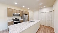 Located on Sand Creek Trail in Colorado Springs, CO, this well-appointed one-bedroom, one-bathroom residence offers a thoughtfully designed single-floor layout with modern finishes throughout. The open-concept kitchen serves as the centerpiece of the living area, anchored by a generous island with a double-basin sink and striking granite-style countertops. Warm-toned cabinetry pairs with a full suite of stainless steel appliances — including a refrigerator, range, and built-in microwave — to create a functional and stylish cooking space. Recessed lighting and wood-look plank flooring lend a clean, contemporary feel that flows seamlessly into the main living area, which is brightened by windows allowing in ample natural light. The bedroom offers a comfortable, carpeted retreat with a large window and a dedicated closet featuring built-in shelving for organized storage. The full bathroom is finished with the same warm cabinetry and granite-style vanity top found in the kitchen, complemented by a full tub-shower combination and wood-look flooring. Clean neutral walls, recessed lighting, and consistent finishes throughout give this residence a cohesive, move-in-ready appeal suited for those seeking modern comfort in Colorado Springs.
