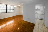 Located on the 18th floor at 140 Carlton Street in Toronto's vibrant Cabbagetown neighbourhood, this 2-bedroom, 2-bathroom unit offers a practical and well-organized layout across a single floor. Warm parquet flooring flows throughout the living spaces and bedrooms, adding a classic character to the interior. The living room is generously proportioned, bathed in natural light through large floor-to-ceiling windows that frame impressive views of the Toronto skyline and surrounding cityscape. The kitchen features white cabinetry, light tile flooring, ample counter space, and white appliances, connecting seamlessly to the entrance area. The spacious primary bedroom includes a walk-in closet and its own city-facing window, while the second bedroom also benefits from a window with urban views. Both bathrooms are finished in clean white tile, with one featuring a full soaker tub and handheld shower fixture. The unit includes a dedicated entrance foyer and a closet for additional storage. Clean white walls throughout contribute to a bright, neutral ambiance, making the space move-in ready and easy to personalize. The high-floor position ensures privacy and unobstructed views of Toronto's dynamic urban landscape.