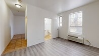 This 330 square foot apartment, located at 4114 W Washington Blvd in Chicago, IL, offers a thoughtful design that maximizes space efficiency. The single-floor layout comprises one bedroom and one bathroom, with the primary bedroom occupying a generous 300 square feet. 

The living area boasts modern gray laminate flooring, creating a sleek and contemporary ambiance. Large windows allow ample natural light to flood the space, enhancing the sense of openness. A wall-mounted heating/cooling unit provides year-round comfort.

The kitchen, while compact, is well-equipped with light wood cabinetry, offering ample storage. Stainless steel appliances, including a refrigerator and built-in microwave, add a touch of modernity. The beige tiled flooring in the kitchen area provides a subtle contrast to the living space.

The bathroom, though small, is functional and bright. It features white fixtures, including a toilet and sink, with a window allowing natural light and ventilation. A shower/tub combination (not visible in the provided images) is likely present.

The bedroom, which takes up the majority of the apartment's square footage, offers a blank canvas for personalization. Its neutral walls and continued laminate flooring maintain the cohesive look of the apartment.

Overall, this apartment presents a well-designed living solution for those seeking an efficient, modern space in an urban setting.