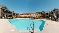 Located at 1733 Bellmeadow Dr in Lancaster, Ohio, this single-floor residence is part of a larger residential community that offers a welcoming atmosphere and notable shared amenities. The community's outdoor area is a standout feature, showcasing a generously sized swimming pool with crystal-clear water, surrounded by a paved deck lined with lounge chairs — ideal for relaxing on sunny days. The pool area is enclosed by a classic wrought-iron style fence and is framed by mature trees and well-kept landscaping, contributing to an open and airy outdoor environment. The surrounding buildings reflect a traditional architectural style, featuring warm earth-tone siding, pitched rooflines, and symmetrical window arrangements that give the community a cohesive and inviting character. The residential unit itself is a single-story layout, offering straightforward and accessible living. Windows fitted with horizontal blinds allow for natural light control throughout the interior spaces. The unit's single-floor design promotes ease of movement and a functional flow between rooms. Overall, this property combines the comfort of private residential living with the added benefit of community outdoor spaces, making it a practical and pleasant place to call home in Lancaster, Ohio.