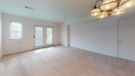 Located at 454 Heather Dr N in Mantua, New Jersey, this single-floor home offers a thoughtfully laid-out interior designed for comfortable everyday living. The kitchen is equipped with warm honey-toned cabinetry, dark granite countertops with a matching backsplash, a corner sink, a dishwasher, and an electric range with an overhead microwave — providing a practical and cohesive cooking environment with tile flooring underfoot. The living and dining areas are carpeted in neutral tones and feature ceiling light fixtures, including a classic chandelier. A set of French doors in the living area allows natural light to fill the space and offers a view to the outdoors. Additional carpeted rooms serve as flexible spaces suitable for bedrooms or office use, with windows that bring in natural light and provide outdoor views. The bathroom vanity area features rich wood cabinetry topped with dark granite countertops, a large mirror, and overhead lighting, with carpet extending into the adjoining space. Throughout the home, the clean white walls and neutral palette create a bright, move-in-ready environment. The overall layout, as seen in the dollhouse view, reflects an efficient single-story floor plan with well-connected living spaces.