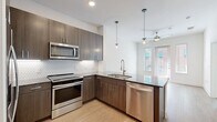 This 550 square foot, one-bedroom apartment in Dallas offers a thoughtfully designed living space. The heart of the home is the gourmet kitchen, boasting sleek stainless steel appliances, dark wood cabinetry, and a striking granite countertop island. The kitchen's hexagonal tile backsplash adds a touch of modern flair.

The spacious bathroom features a large vanity with ample storage, topped with a granite countertop that complements the kitchen. A glass-enclosed shower with a curved rod adds a touch of elegance. The bedroom, measuring 140 square feet, is carpeted for comfort and features dual windows that flood the space with natural light.

Throughout the apartment, you'll find crisp white walls, recessed lighting, and ceiling fans. The living area connects seamlessly to the kitchen, creating an open-concept feel. A walk-in closet provides generous storage space. Hardwood floors in the main living areas contrast beautifully with the carpeted bedroom, adding warmth and texture to the space.

This apartment combines modern amenities with a thoughtful layout, making efficient use of its 550 square feet to create a comfortable and stylish urban dwelling.