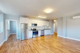 Located at 27 Water Street in Wakefield, Massachusetts, this well-appointed 2-bedroom, 2-bathroom residence offers a thoughtfully designed single-level layout with modern finishes throughout. The open-concept kitchen and living area serves as the heart of the home, showcasing warm hardwood flooring, crisp white shaker cabinetry, granite countertops, a classic subway tile backsplash, and a full suite of stainless steel appliances including a refrigerator, range, microwave, and dishwasher. Natural light flows freely through the space, enhancing its clean, contemporary feel.

A central hallway connects the main living area to the two bedrooms, each finished with the same hardwood flooring and soft, neutral wall tones. The spacious primary bedroom features dual windows that invite ample natural light and outdoor views, along with a wall-mounted mini-split unit for individual climate control. The second bedroom also benefits from natural light and includes a built-in closet. Both bedrooms offer dedicated closet storage.

The two bathrooms are finished with light tile flooring, tiled tub-and-shower combinations with sliding glass enclosures, and granite-topped vanities, providing a clean and functional design. The overall ambiance of the residence is bright, modern, and move-in ready.