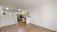 Located at 2201 4th Avenue in Seattle's Belltown neighborhood, this one-bedroom, one-bathroom residence offers a thoughtfully designed layout across a single floor. The open-plan living, dining, and kitchen area forms the heart of the unit, finished with warm wood-tone laminate flooring throughout. The kitchen is well-equipped with stainless steel appliances—including a refrigerator, gas range, microwave, and dishwasher—complemented by light wood cabinetry, dark countertops, and a convenient breakfast bar that separates the kitchen from the living space. A skylight above the kitchen adds a welcome touch of natural light. The living area is bright and airy, with large French doors flanked by windows that open onto a private balcony, inviting natural light and outdoor views of the surrounding cityscape. The bedroom offers a cozy and functional space, with a dedicated closet for storage. The bathroom features a full tub-shower combination, a wood-toned vanity, and continues the clean, neutral aesthetic found throughout the unit. An entrance foyer and in-unit laundry add everyday practicality to this efficiently designed urban residence.