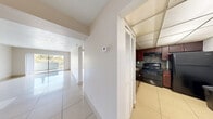Located at 1981 NW 43rd Terrace in Lauderhill, Florida, this two-bedroom, two-bathroom residence offers a well-organized single-floor layout designed for comfortable everyday living. Polished large-format ceramic tile flooring extends throughout the home, creating a bright and cohesive aesthetic in every room.

The spacious living room serves as the heart of the home, featuring neutral walls, a textured ceiling, and a sliding glass door that opens to a private balcony overlooking lush greenery — bringing in abundant natural light and a refreshing outdoor connection.

A hallway connects the living area to the kitchen, which is outfitted with rich dark wood cabinetry, a mosaic tile backsplash, and black appliances, offering both style and practicality. A pantry provides additional storage conveniently nearby.

The generously sized primary bedroom features tile flooring, a dedicated closet, and a window that allows natural light to fill the space. The second bedroom also benefits from bright natural light through a large window. Both bathrooms are clean and functional, each equipped with a full tub-shower combination and tiled surrounds.

Four closets distributed throughout the unit ensure ample storage, while the overall layout — including a connecting hallway — provides a logical and efficient flow between all areas of the home.