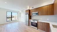 This contemporary 1-bedroom apartment in Los Angeles offers 510 square feet of thoughtfully designed living space. The open-concept layout maximizes efficiency, seamlessly blending the kitchen, living, and dining areas. The kitchen boasts sleek wood cabinetry, stainless steel appliances, and a clean white backsplash, creating a modern aesthetic. 

The 150-square-foot bedroom provides a comfortable retreat, featuring large windows that flood the space with natural light. The bathroom showcases a modern design with a glass-enclosed shower, neutral tiling, and updated fixtures. Throughout the apartment, warm wood flooring adds warmth and continuity.

Large windows in the living area and bedroom offer scenic city views, enhancing the sense of space and connection to the urban surroundings. Recessed lighting and crisp white walls contribute to the bright, airy ambiance. The apartment's thoughtful design incorporates ample storage solutions, making the most of the compact floor plan.

Located at 10425–10431 Santa Monica Blvd, this apartment combines style, functionality, and a prime location in the heart of Los Angeles, making it an ideal urban dwelling for those seeking a modern lifestyle in a vibrant city setting.