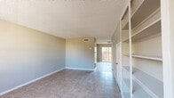 Located at 6869 Enid Ct in El Paso, TX, this two-story home offers a well-organized layout spread across two floors of nearly equal size. The main level features a bright and open living room with neutral-toned walls, tile flooring, and built-in shelving, flowing naturally into the dining area and kitchen. The kitchen is equipped with rich, dark wood cabinetry, granite countertops, a central island, and tile flooring—providing both functional workspace and storage. A pantry closet is conveniently tucked adjacent to the refrigerator. The dining area benefits from abundant natural light through a sliding glass door that opens directly to a private, fenced backyard patio. Three bathrooms are distributed throughout the home, including one featuring a soaking tub. The spacious primary bedroom on the upper floor includes wood-look tile flooring, a ceiling fan, and a window with natural light, complemented by two dedicated closets offering generous storage. Textured ceilings are a consistent architectural detail throughout the home. With four total closets and a thoughtful two-floor layout, this El Paso home balances practicality and comfort in a compact yet efficiently designed footprint.