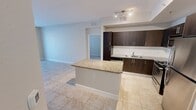 Located at 580 Christina Dr in Royal Palm Beach, Florida, this single-story residence offers a practical and comfortable layout across two bedrooms, two bathrooms, and a dedicated closet. The interior features a neutral color palette throughout, with light beige walls and clean white trim creating a bright, cohesive atmosphere. Common areas and wet spaces are finished with classic square tile flooring, while the bedrooms feature soft carpeting underfoot. The kitchen is equipped with stainless steel appliances, dark cabinetry, and granite countertops that extend to a breakfast bar, opening toward the main living area for a connected, functional flow. Arched architectural detailing adds a subtle decorative touch to interior doorways. The spacious primary bedroom includes direct access to a walk-in closet and connects conveniently to the rest of the unit. Both bedrooms are fitted with ceiling fans and windows dressed with horizontal blinds, allowing for natural light and ventilation. Each bathroom features a tub-shower combination with white square tile surround, tile flooring, and granite vanity countertops. The layout is efficient and well-organized, offering a comfortable living environment in a residential community in Palm Beach County.